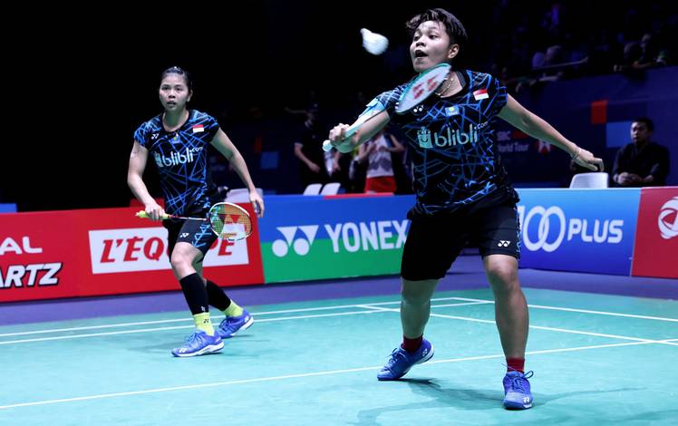 Greysia Polii/Apriyani Rahayu mengembalikan shuttlecock.