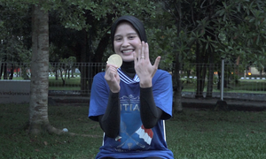 Hanna Ramadini (PB Mutiara Cardinal) memamerkan medali juara dan cincin tunangannya.