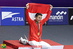 Jonatan Christie membentangkan bendera merah putih di podium juara.