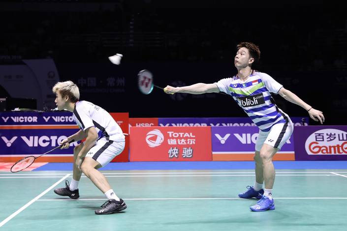 Kevin Sanjaya Sukamuljo/Marcus Fernaldi Gideon mengembalikan shuttlecock.